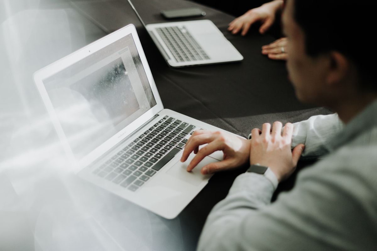 Profissional avaliando tendências de web design na tela do notebook