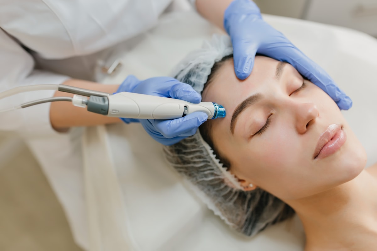 Profissional aplicando procedimento estético facial em clínica
