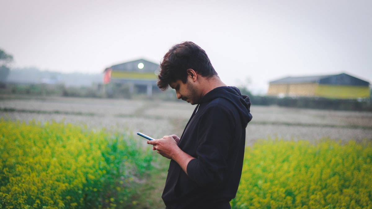 Produtor rural consultando o celular em meio à lavoura, com internet em 98% das propriedades