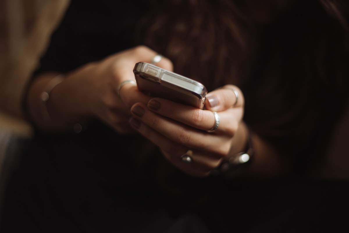 Paciente usando o celular para marcar consulta na clínica odontológica