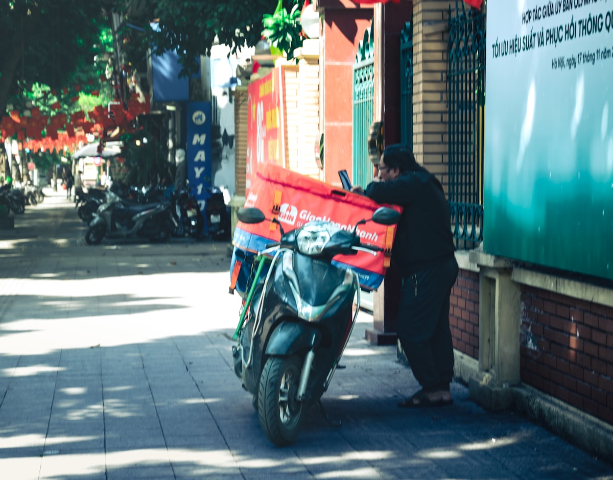Entregador de delivery em moto com bag de pedidos na rua