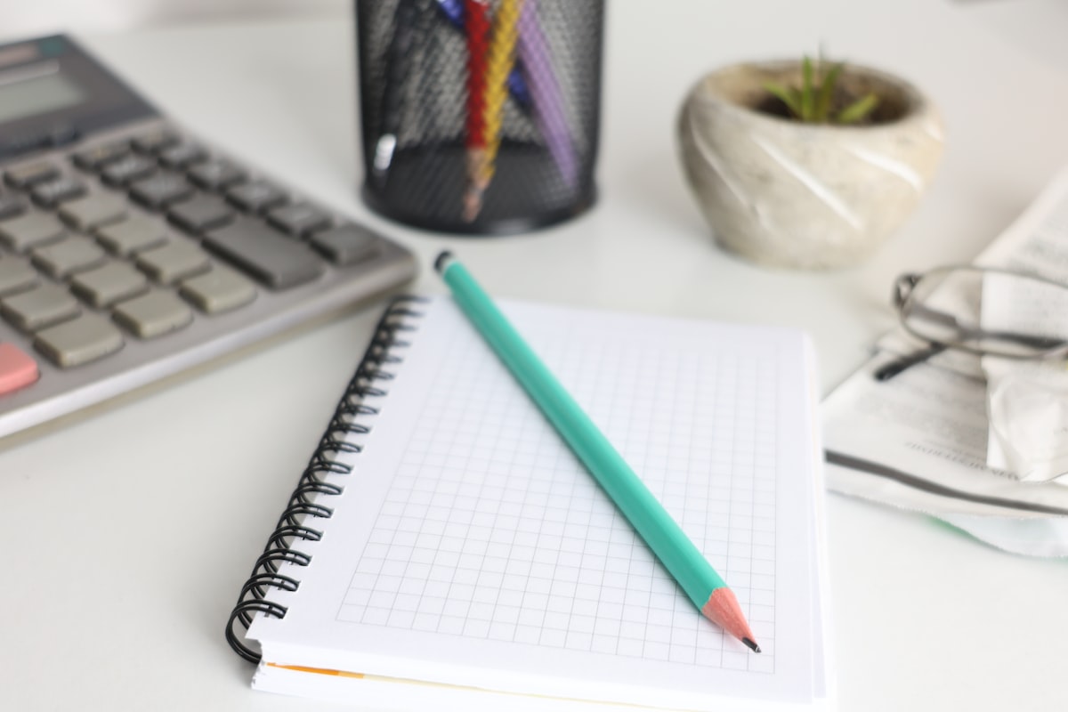 Calculadora e bloco de anotações em mesa de escritório de contabilidade
